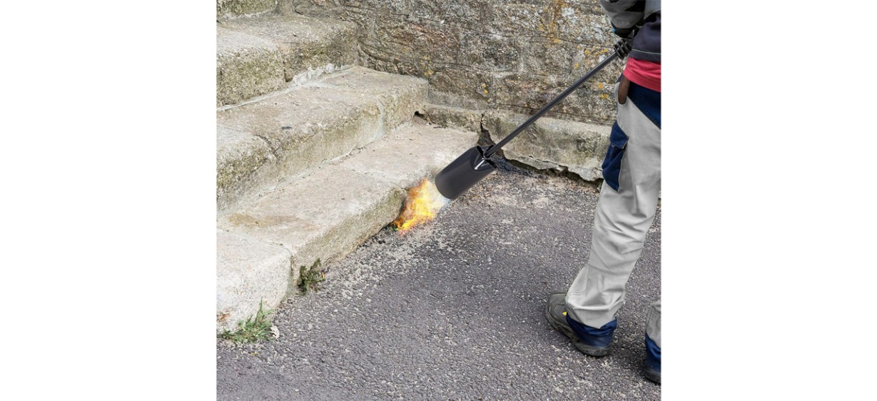 Person using Ivation Heavy-Duty Weed Burner on weeds near steps