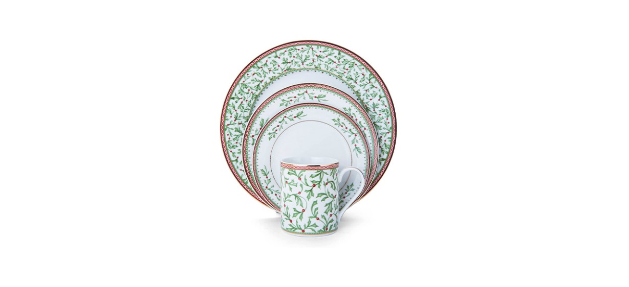 A set of white dinner plates and mugs with gold edges and images of holly leaves