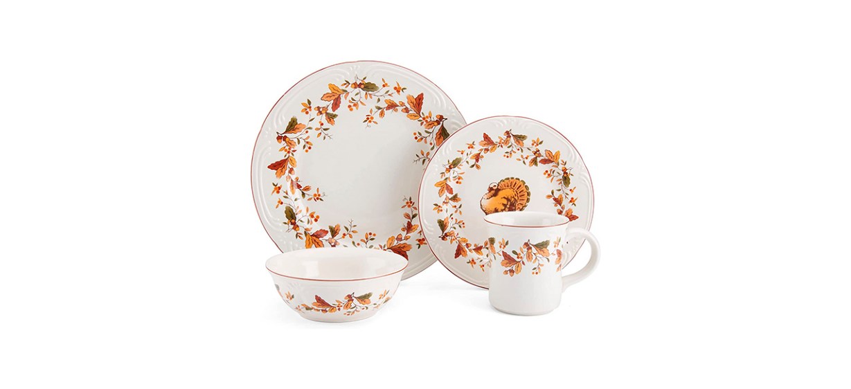 A set of white plates, bowls and mugs with gold edges and bordered in an orange leaf design