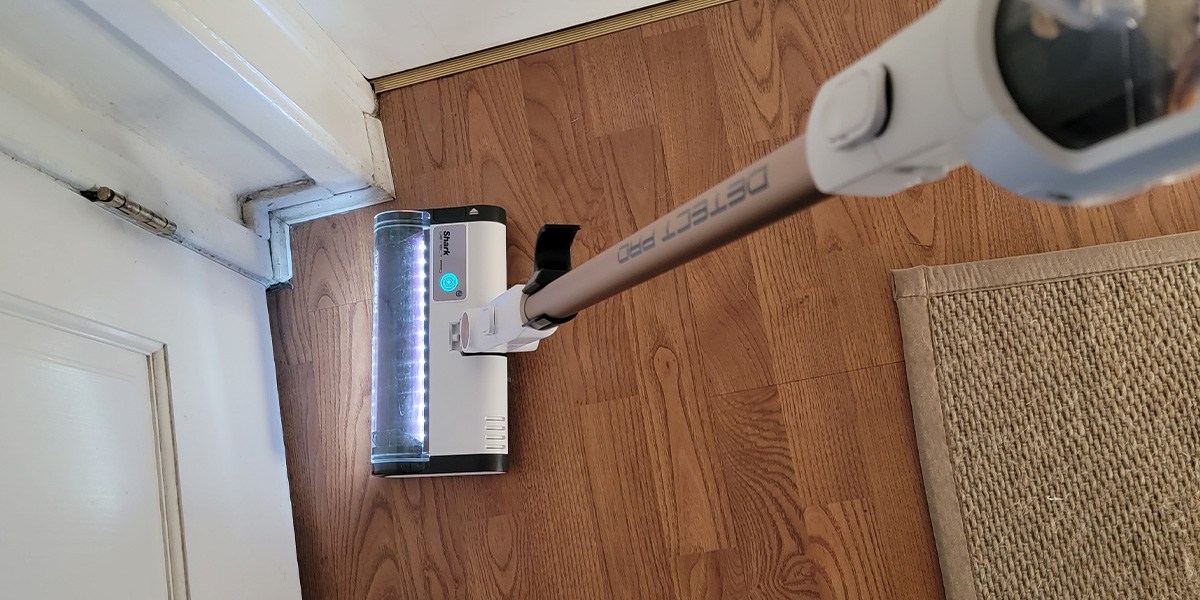 Shark Cordless Detect Pro on hard flooring moving toward corner Shark Cordless Detect Pro on hard flooring moving toward corner