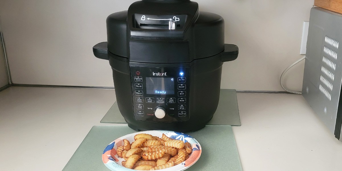 Instant Pot Duo Crisp on counter with plate of fries in front