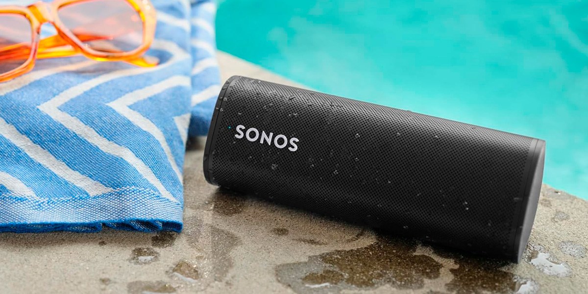 Sonos Roam on pool deck next to towel and sunglasses