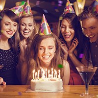 a woman blowing the birthday candles