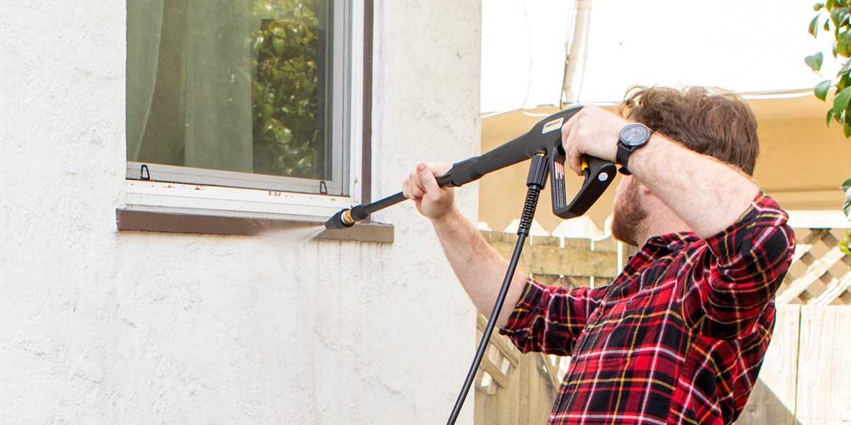 Person cleaning area around window using Kärcher K1700 Pressure Washer